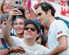  ?? JASON DECROW/AP PHOTO ?? Roger Federer of Switzerlan­d poses with a fan after defeating Nick Kyrgios of Australia during the third round Saturday at the U.S. Open in New York. Federer swept Kyrgios 6-4, 6-1, 7-5.