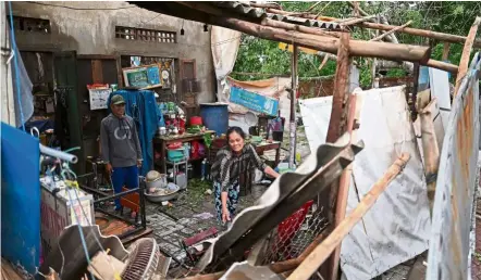  ?? — AFP ?? Picking up the pieces: A woman clearing debris from her house in Quang Ngai province after it was damaged by Typhoon Molave.