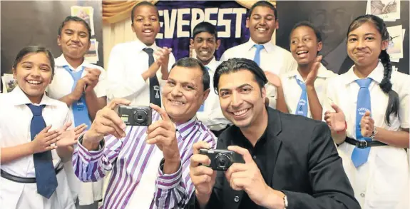  ?? Picture: JACKIE CLAUSEN ?? SAY CHEESE: Principal Jaychand Neerachand, left, and photograph­er Mikail Hansa with Everest Primary pupils