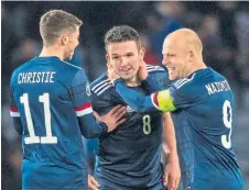  ??  ?? John McGinn (centre) is congratula­ted after levelling for Scotland against Kazakhstan.