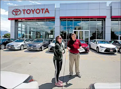  ?? AP/ RICK BOWMER ?? A shopper visits with a salesman for Mark Miller Toyota in Salt Lake City, in June. Toyota’s sales of new cars and trucks rose 3.6 percent in July, bucking the trend of lower sales for U. S. automakers.