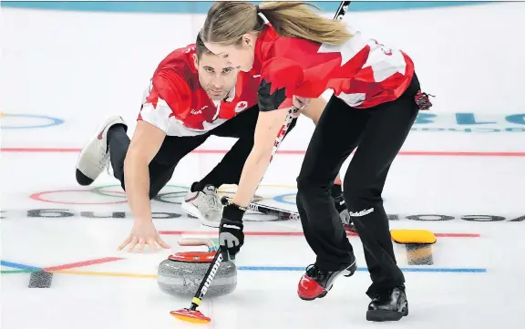  ?? NATHAN DENETTE/THE CANADIAN PRESS ?? Kaitlyn Lawes and John Morris get down to business in the mixed doubles gold-medal game against Switzerlan­d, which they won 10-3.