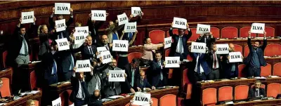  ??  ?? Un cartello con scritto «Ilva» è stato innalzato dai senatori della Lega al Senato durante la discussion­e sul decreto Imprese