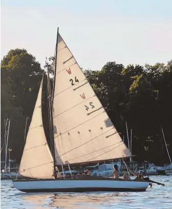  ??  ?? SMOOTH SAILING: A sailboat passes by on Wannsee lake in Berlin. Top right, workboats are tied up along the Spree River. At right, people enjoy Muggelsee lake.