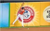  ?? MARK BROWN/GETTY IMAGES ?? Giancarlo Stanton loses his glove over the fence after attempting to catch a Chris Taylor fly ball.