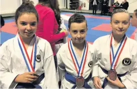  ??  ?? Pictured from left to right: Ella Frost, Brandon Norman and Scarlett Hubbard who won 10-12year-old Kata Team Bronze.
