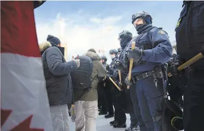  ?? ROBERT BUMSTED AP ?? Police move in to clear protesters from downtown Ottawa near Parliament Hill on Saturday. Police resumed pushing back protesters on Saturday after arresting more than 100 and towing away vehicles in Canada’s besieged capital.