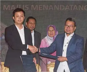  ?? PIC BY NUR ADIBAH AHMAD IZAM ?? Malaysian Islamic Chamber of Commerce Selangor chairman Datuk Mat Ghazali Abd Rakim (right) exchanging documents with Malaysia Northwest China Chamber of Commerce chairman Abdullah He Ping in Kuala Lumpur yesterday. With them is Housing and Local Government Minister Zuraida Kamaruddin (second from right).