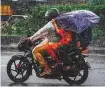  ?? AFP ?? A motorist braving the deluge with his family in Hyderabad yesterday.
