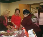  ?? Diane Wagner / RN-T ?? Georgia Northweste­rn Technical College cosmetolog­y instructor Sonja Everett (from left) and students Alicia Flowers, Marilyn Hernandez and Sheliah Hogg pack up the remnants of the luch buffet for delivery to the Davies Homeless Shelter after treating...