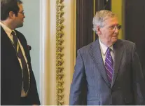  ?? ZACH GIBSON/BLOOMBERG NEWS ?? Senate Majority Leader Mitch McConnell, R-Ky., right, leaves the Senate chamber Thursday. The Senate blocked a bipartisan proposal to protect young undocument­ed immigrants from deportatio­n.