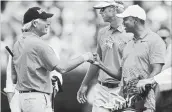  ?? CURTIS COMPTON
TNS ?? Tiger Woods gets a fist bump from Fred Couples on the practice range at Augusta National Monday.