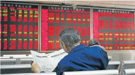  ?? Picture: REUTERS ?? CAUSE AND EFFECT: An investor reads the finance section of a newspaper at a brokerage in Beijing. China’s stock market shutdown in January hit many stocks on the JSE