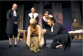  ?? PHOTOS BY ANN MARIE WATSON ?? In front, the Rev. John Hale (Matt Jones), right, implores Tituba (Shemika Berry) to confess to witchcraft, observed in the background by the Rev. Samuel Parris (Larry Daniele), Ann Putnam (Brenna Prestidge) and Thomas Putnam (Keith Linville) in the Port Tobacco Players’ production of “The Crucible.”