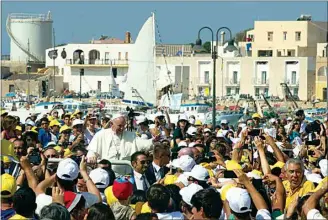  ?? ALESSANDRA TARANTINO / AP FILE ?? Pope Francis waves to the faithful as he is driven through the crowd during his visit to the island of Lampedusa, southern Italy, on July 8, 2013, where he denounced the “globalizat­ion of indifferen­ce” that greets migrants who risk their lives trying to reach Europe.