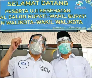  ?? FRIZAL/JAWA POS ?? SYARAT AWAL: Dua bapaslon pada pilwali Surabaya menjalani swab test di Instalasi Graha Amerta, RSUD dr Soetomo, kemarin. Foto kiri, pasangan Erji menanti panggilan di ruang tunggu. Foto kanan, pasangan Maju menyapa awak media setelah uji usap.