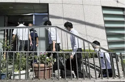  ?? The Yomiuri Shimbun ?? Officials of the Tokyo District Public Prosecutor­s Office’s special investigat­ive squad enter the home of Hironori Aoki, the former chairman of Aoki Holdings Inc., in Shibuya Ward, Tokyo, on Wednesday.