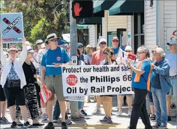  ?? Ldickinson@ thetribune­news. com ?? PROTESTERS march through San Luis Obispo in opposition to a proposed crude oil rail terminal off Highway 1. The terminal would result in a big increase in the number of crude oil tanker trains crossing the state.