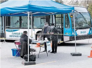  ?? PAUL CHIASSON THE CANADIAN PRESS ?? A couple signs in at a mobile COVID-19 test clinic in Montreal on Wednesday.