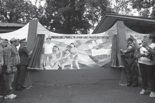  ?? BING GONZALES ?? BRIG. GEN. Filmore Escobal, Police Regional Office XI, and Davao City Police Office director Col. Kirby John Kraft unveil the Wall of Peace, which is part of the campaign to end local Communist armed conflict, on Friday, Feb. 14.