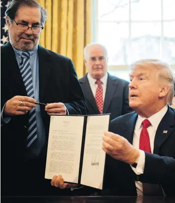  ?? JIM WATSON / AFP / GETTY IMAGES ?? United Steelworke­rs Union Internatio­nal President Leo Gerard, left, looks on after Donald Trump signs a bill on steel and aluminum tariffs in the Oval Office. The inclusion of Canada in the list of countries affected by Trump’s trade action has left many USW union members in Canada on the wrong side of the tariff wall, John Ivison writes.