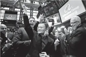  ??  ?? From top: Jack Ma talks to his fellow founders of Alibaba in Hangzhou in 1999; Ma (left) performs in an outlandish costume during a ceremony celebratin­g the 10th anniversar­y of Alibaba; Ma (center) raises the ceremonial mallet before striking a bell during the company’s IPO at the New York Stock Exchange in 2014. — IC