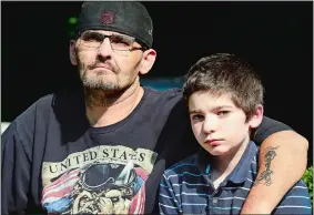  ?? SARAH GORDON/THE DAY ?? Timothy Wilcox sits with his son Bryan Mossor, 14, on Monday at their home in Norwich.