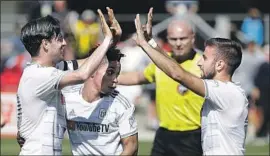  ?? Justin Cooper Associated Press ?? LAFC FORWARD Carlos Vela, left, forward/midfielder Latif Blessing and forward Diego Rossi celebrate a goal against D.C. United on Saturday.