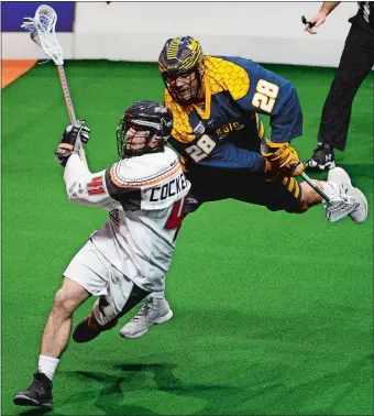  ?? SARAH GORDON/THE DAY ?? New England’s Mark Cockerton (41) evades Georgia’s Zed Williams and takes a shot on goal during the Black Wolves’ season-opening 13-11 win over the Swarm on Friday night at Mohegan Sun Arena.