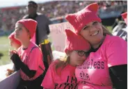  ??  ?? Zoe Rodis, 8, leans on her mother, Jennifer Rodis, during the boisterous rally in Las Vegas.