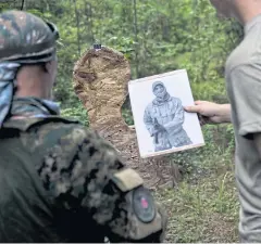  ??  ?? READY FOR COMBAT: Members of the Georgia Security Force put targets up before the group participat­es in live-fire training during a field exercise in Jackson.