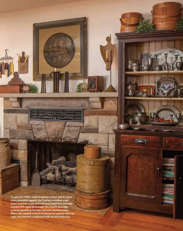  ??  ?? To give the 1950s stone fireplace in their family room more primitive appeal, the Cyphers installed a gas insert and iron grate and will soon cover the concrete mantel with aged barnwood. The hearth provides a classic backdrop for their favorite country wares. When Jan needed a hutch to house her pewter and rag rugs, she married a cupboard with an old bookcase.