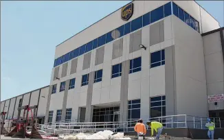  ?? JENNA EASON / JENNA.EASON@COXINC.COM ?? Employees work Monday on finishing constructi­on of UPS’ Southeast ground delivery hub on the westside of Atlanta. The sprawling facility will begin operations Aug. 6.