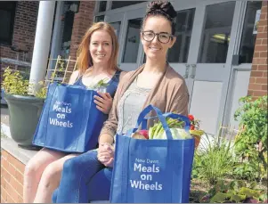  ?? NIKKI SULLIVAN/CAPE BRETON POST ?? Claire Turpin, front, and Kathleen Whelan show off bags full of fresh produce and meat that will be delivered to seniors on Thursday as part of the age-friendly food box pilot program. The program is being done through meals on wheels and continues...