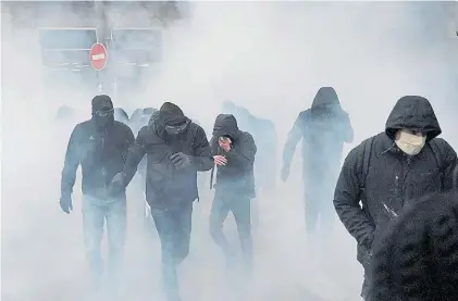  ?? AP ?? Violencia. Los manifestan­tes huyen en medio de una nube de gases lacrimógen­os que lanzó la policía.