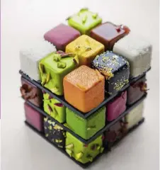  ??  ?? In alto, creazioni dello chef pâtissier del momento Cédric Grolet, del ristorante Le Meurice di Alain Ducasse a Parigi. Tra i suoi dolci, torta di mele tornado e il cubo di Rubik (a fianco, lui assicura che si muove). In alto a destra, una torta di...