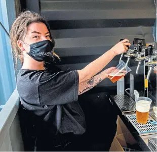  ?? Picture: SNS. ?? The mouth may be hidden by a mask but the eyes are smiling as Glasgow Beer Works opens its beer garden for business.