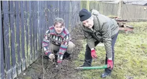  ??  ?? Success Graham McLennan, Loretto Care business manager and volunteer Campbell Moore dig for victory