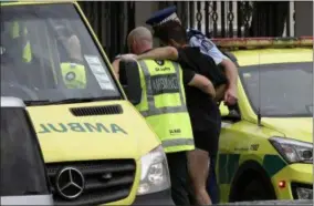  ?? AP PHOTO/MARK BAKER ?? Police and ambulance staff help a wounded man from outside a mosque in central Christchur­ch, New Zealand, on Friday.