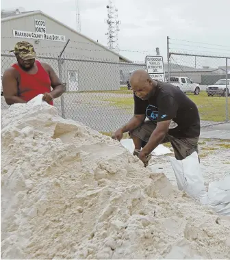  ?? AP.PHOTO ?? BAG JOB: Gulfport, Miss., residents shovel sand into bags yesterday while preparing for Subtropica­l Storm Alberto to make its way through the Gulf of Mexico.