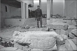  ?? ASSOCIATED PRESS] [KHALID MOHAMMED/THE ?? Iraqi federal police inspect the inside of the heavily damaged museum in Mosul. Most of the artifacts appeared to be destroyed, with the ashes of ancient manuscript­s covering some floors.