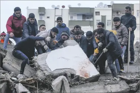  ?? In Adana, Turkey, on Monday. KHALIL HAMRA/AP ?? MEN SEARCH FOR PEOPLE AMONG THE DEBRIS IN A DESTROYED BUILDING