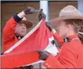  ?? GARY NYLANDER/The Daily Courier ?? Insp. Paul MacDougall and other RCMP members take part in a flag-lowering ceremony Tuesday at Kelowna’s old RCMP detachment on Doyle Avenue.