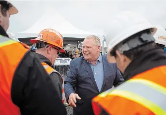  ?? CHRIS YOUNG THE CANADIAN PRESS ?? Premier Doug Ford greets workers at a constructi­on site in Brampton as he starts his re-election campaign. Ford insisted Wednesday it would be imprudent to divulge the price-tag on Highway 413 before the contracts are tendered.