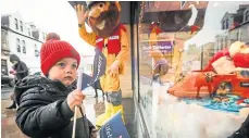  ?? ?? Joseph Reilly, 3, above, and Olive Lorimer, 2, are captivated by the store’s Christmas window display.