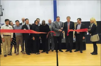  ?? Photo by Ernest A. Brown ?? Lt. Gov. Dan McKee, along with Lincoln Town Administra­tor T. Joseph Almond and Cumberland Mayor Bill Murray, center, and Central Falls Mayor James Diossa, left, joined by faculty, staff and students, cut the ribbon during the official unveiling of the...