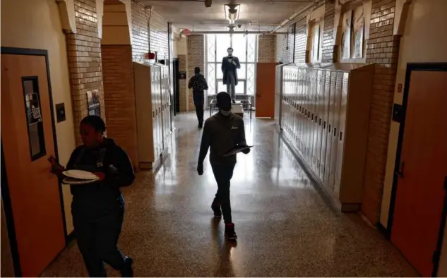  ?? ?? Students passed through a hallway at Jeremiah E. Burke High School in Grove Hall, one of the few traditiona­l high schools in Boston.