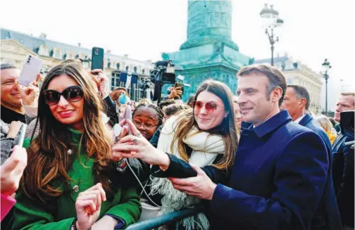 ?? Agence France-presse ?? ↑
French President Emmanuel Macron poses for a selfie on Internatio­nal Women’s Day in Paris on Friday.