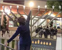  ?? ROD THORNBURG / FOR THE CALIFORNIA­N / FILE ?? Bakersfiel­d Mayor Karen Goh lights the shamash of the menorah for the start of Hanukkah at The Marketplac­e in 2019. This year’s celebratio­n will be Nov. 28 at the southwest shopping center.