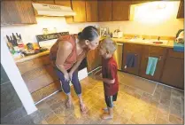  ?? Rick Bowmer / Associated Press ?? Misty Dotson kisses her son at their home Tuesday in Murray, Utah. Dotson is a 33yearold single mother of two boys, ages 12 and 6, who goes to Planned Parenthood for care through the Title X program. The organizati­on this week announced it is pulling out program rather than abide by a new Trump administra­tion rule prohibitin­g clinics from referring women for abortions.